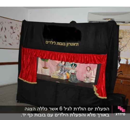 תיאטרון בובות עם וילון אדום ודמויות על במה